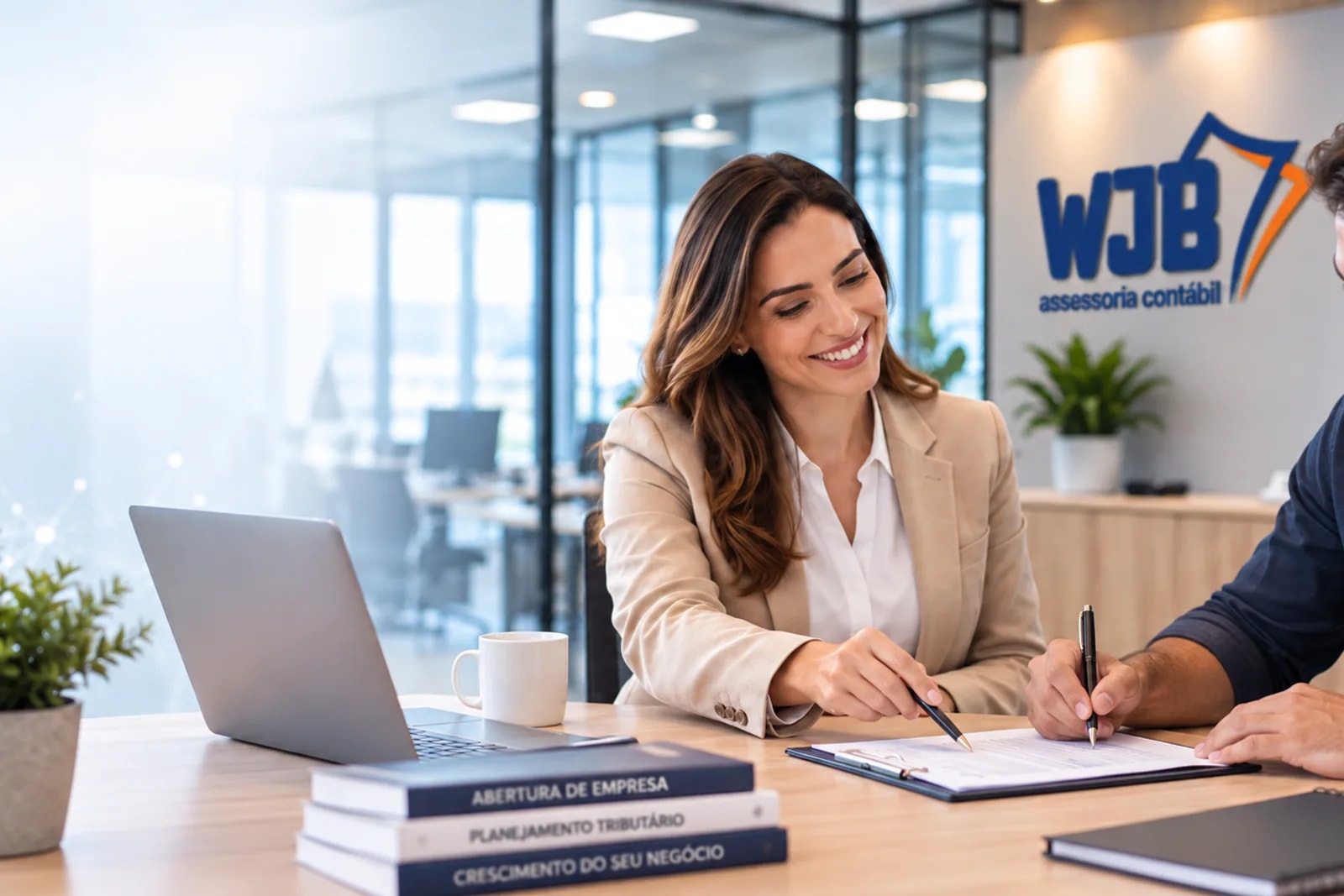Consultora e cliente assinando documento de abertura de empresa no escritório da WJB, com livros sobre abertura de empresa e planejamento tributário na mesa